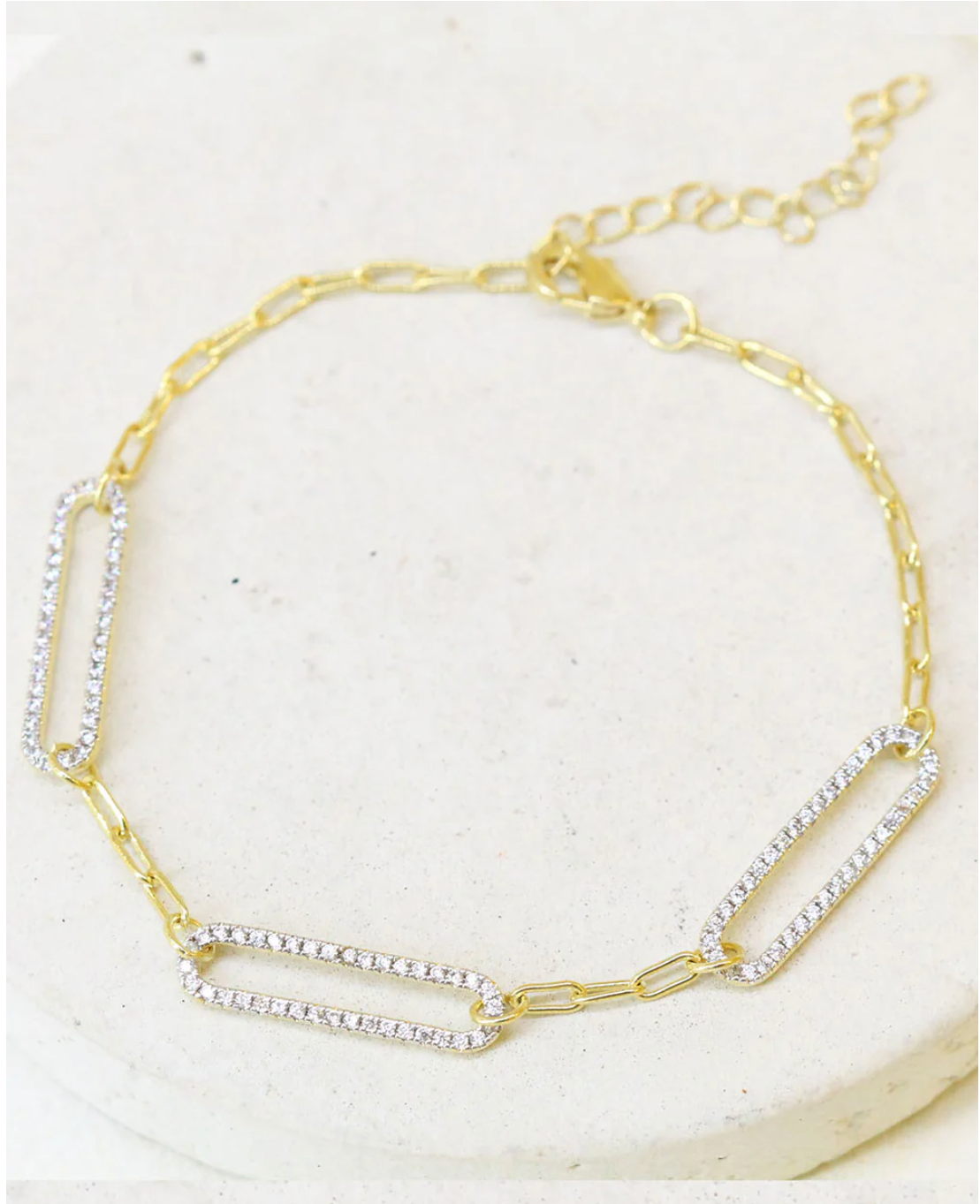 A gold-plated zirconia paperclip bracelet with adjustable links and zirconia accents.