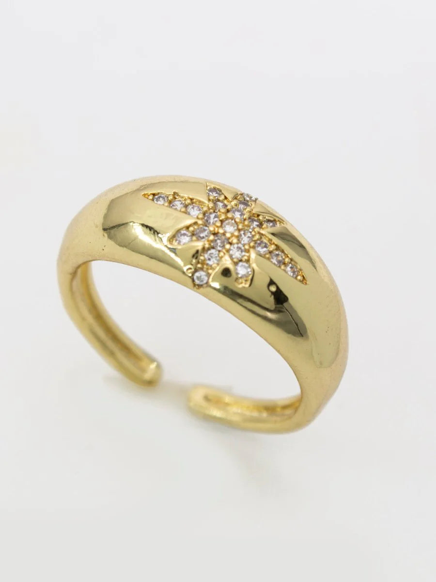 A gold-plated ring with a star-shaped zirconia inlay in the middle, on a white background.