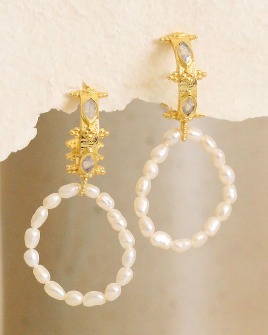 Freshwater Pearl hoop earrings with moonstones and gold clasps on a textured beige background